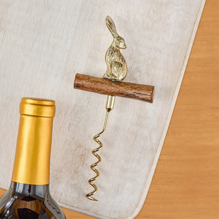 The BE HOME - HARE CORKSCREW by BE HOME, INC features a wooden log-shaped handle and a gold upright rabbit on top, making this charming wine bottle opener a unique hostess gift.