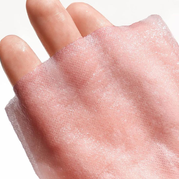 Close-up of a hand draped in a shimmering pink sheet mask fabric, showcasing its fine, textured fibers and luminous finish designed for a brightening and hydrating skincare routine.