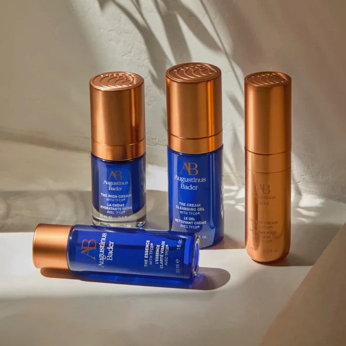 Augustinus Bader The AB Essentials Set skincare bottles with blue glass and gold caps