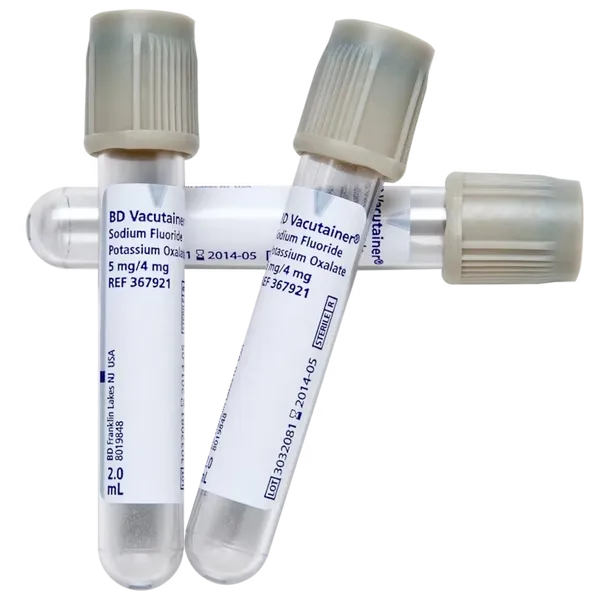 Three BD Vacutainer tubes, containing sodium fluoride and potassium oxalate, lie on a surface. Each tube is labeled with lot numbers and expiration dates (2014-05). They are 2.0 mL.
