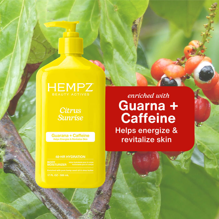 Hempz Beauty Actives Citrus Sunrise Moisturizing Body Lotion with Guarana + Caffeine on a green leafy background