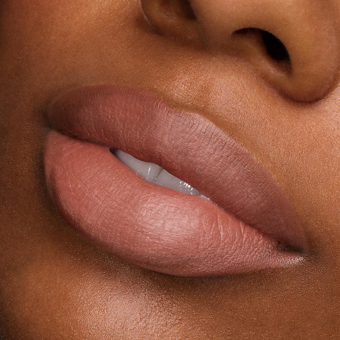 Full lips wearing ColourPop Power Pout Lipstick, Bella! Where the Hell Have You Been, Loca?, showcasing a creamy nude-rose shade with a soft-matte finish in a studio close-up, emphasizing smooth texture, precise edges, and full-coverage payoff.