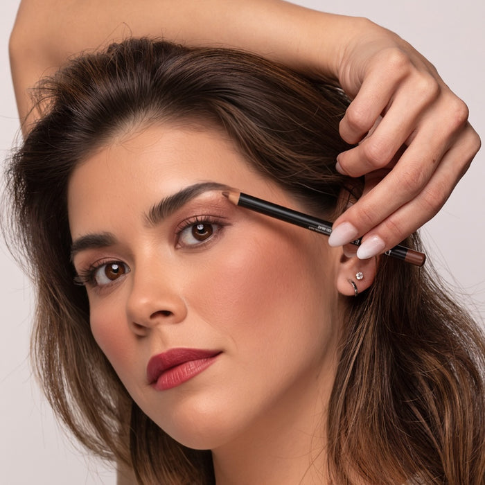 Woman applying Demure Dark Brown Brow Liner with a neutral background