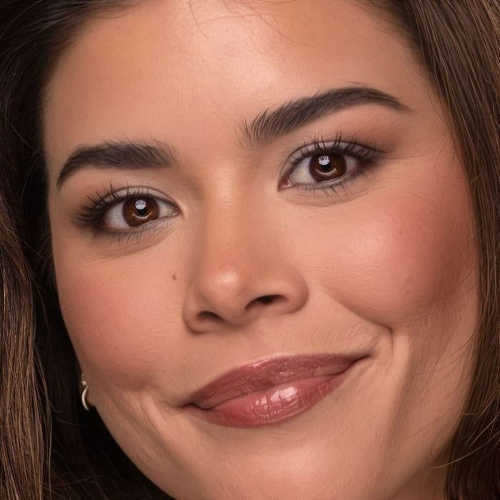 Close-up of a woman's face with a soft smile wearing Demure makeup
