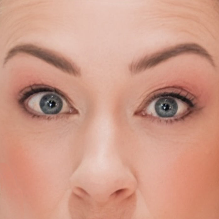 Closeup of a woman's eyes wearing Demure Dark Brown Eye Liner, Light Brown Brow Liner and Demure Brown Mascara