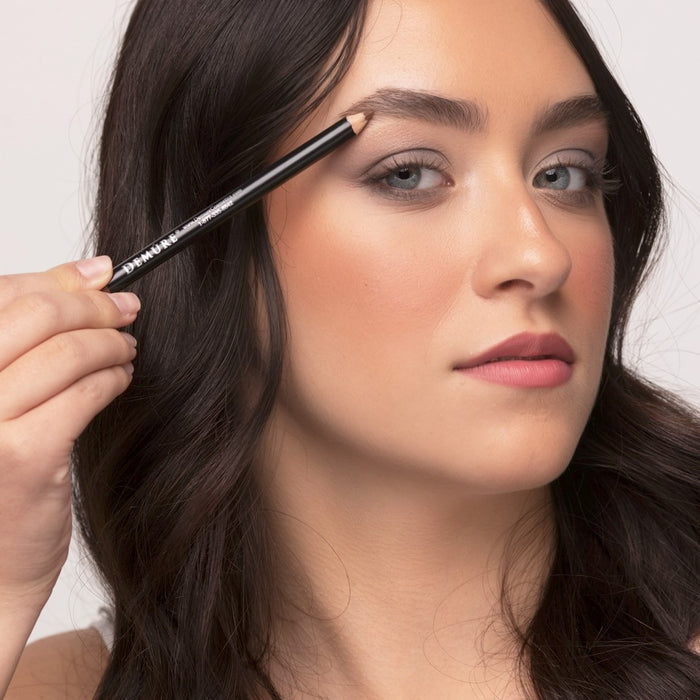 Woman applying Demure Medium Brown Brow Liner to her left brow
