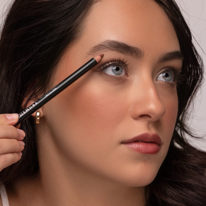 Woman applying Demure Medium Brown Brow Liner to her brows.