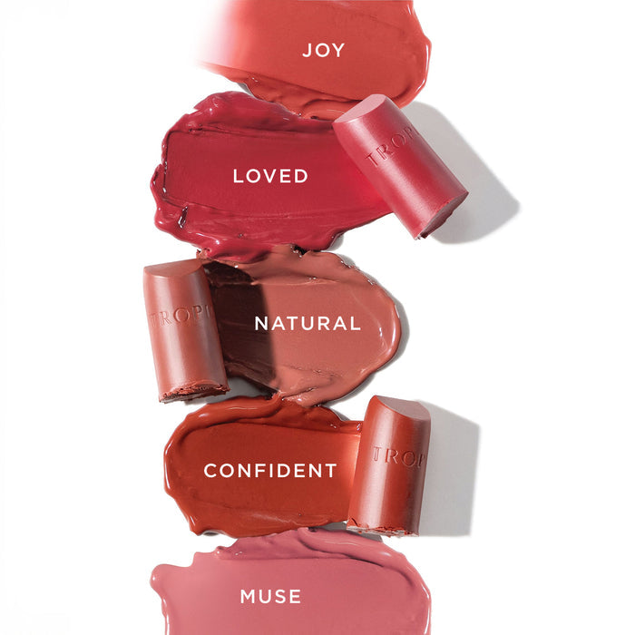 Five Tropic Butter Tint swatches labelled Joy, Loved, Natural, Confident, and Muse, with matching lipstick bullets displayed.
