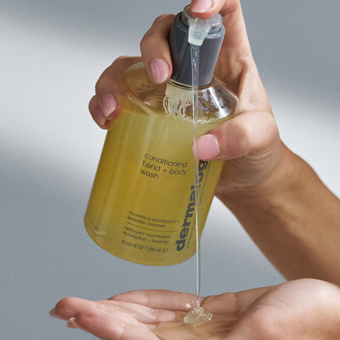 Hand holding a bottle of Dermalogica conditioning hand and body wash with clear liquid being poured.