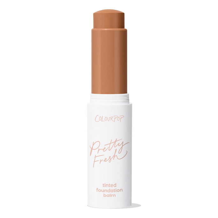 ColourPop Pretty Fresh Tinted Foundation Balm in Dark 18 - twist-up stick stands open with the warm deep shade bullet extended, housed in a white tube with peach lettering against a clean white background.