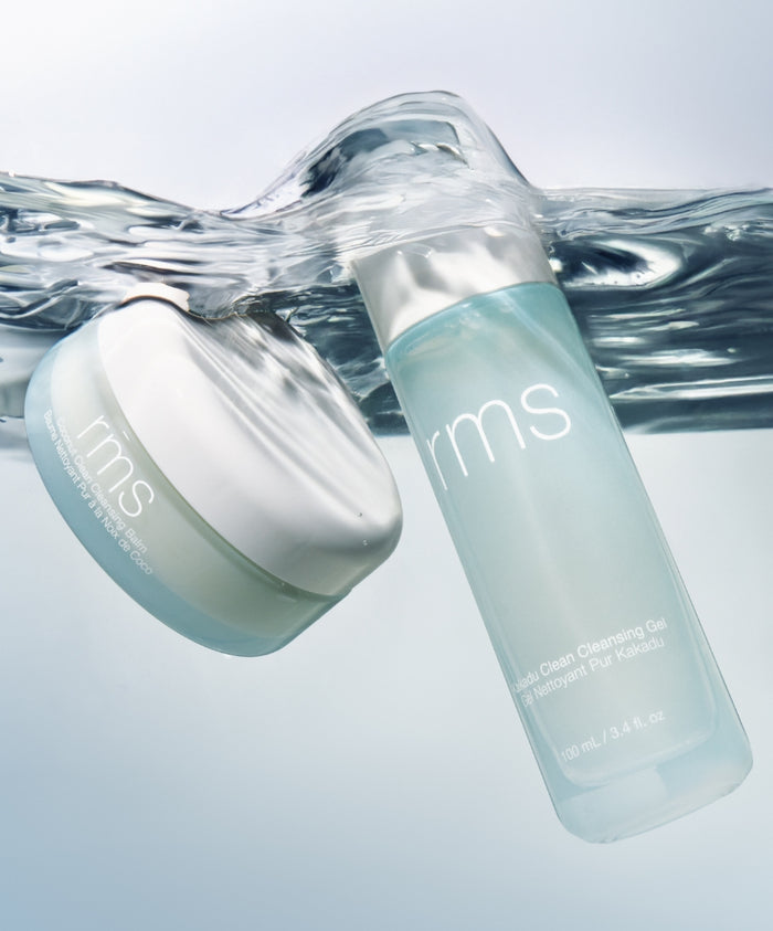 Two RMS Beauty skincare products submerged in clear water, featuring a jar and a bottle, showcasing the Double Clean Cleanser Duo in fresh, clean packaging.