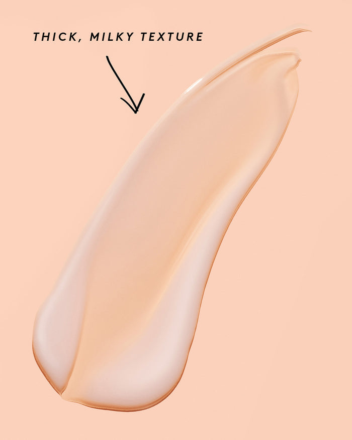 smear of fat water on a peach background noting its thick, milky texture