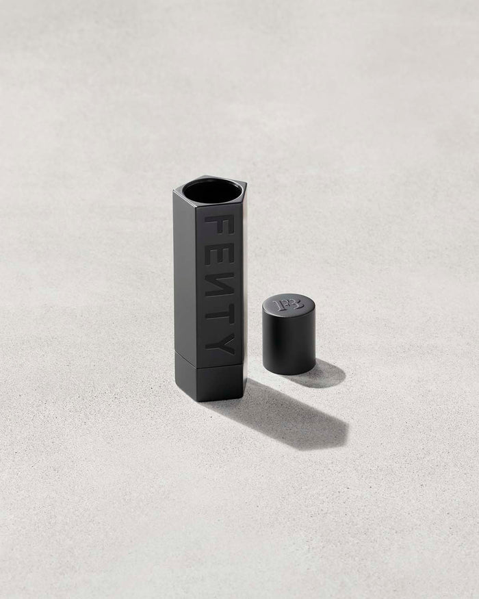 An open Fenty Icon refillable lipstack case in matte black.