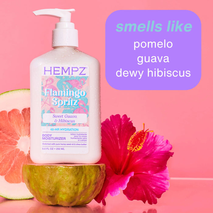 Hempz Flamingo Spritz body moisturizer bottle with pomelo, guava, and hibiscus elements on a pink background.