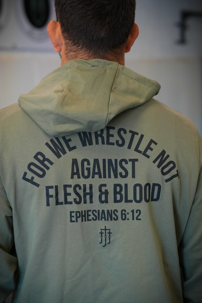 Rear view of man wearing pine hoodie with text "FOR WE WRESTLE NOT AGAINST FLESH & BLOOD EPHESIANS 6:12"