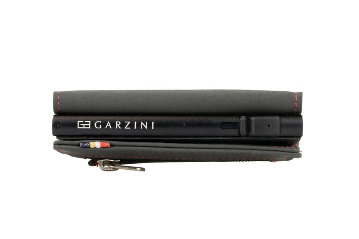 A closed GARZINI - SLIM TRIFOLD RFID-BLOCKING LEATHER WALLET WITH METAL CARD HOLDER AND COIN POCKET IN CARBON WITH RED sits beside a black "GARZINI" pen, both viewed from the side.