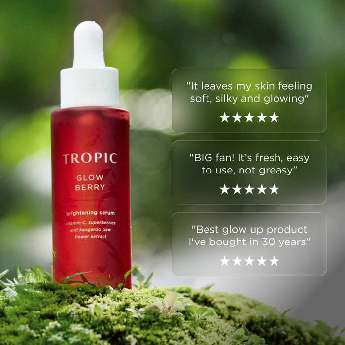 Tropic Glow Berry brightening serum bottle on moss with customer review quotes and five-star ratings displayed beside it.