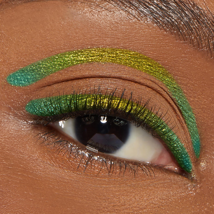 Shimmering lime and emerald ColourPop Crème Gel Liner, shade Good Shift, creates bold graphic lines along the upper lash line and above the crease on a close-up eye with long lashes and a neatly groomed brow.