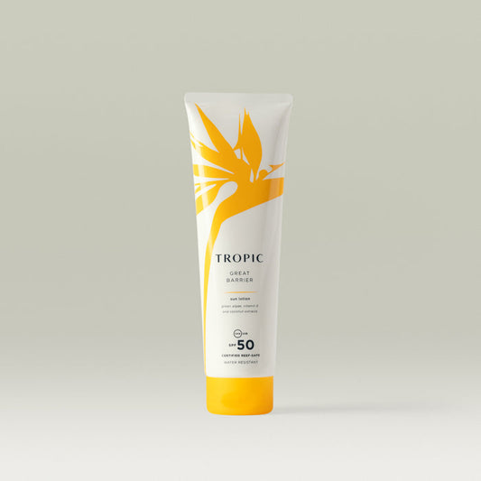 A white tube of Tropic Great Barrier Sun Lotion with SPF 50, showcasing a yellow tropical leaf design and text highlighting 'certified reef-safe' and 'water resistant'.