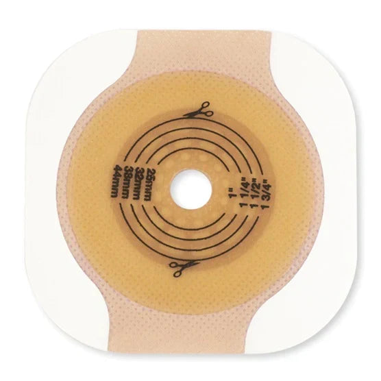 A beige adhesive wafer with a central opening, displays measurement markings in millimeters and inches, sits on a white background. 25mm, 28mm, 32mm, 38mm, 44mm, 1", 1 1/4", 1 1/2", 1 3/4".