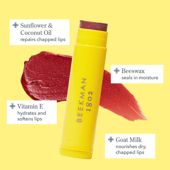 Infographic of Beekman 1802’s Goat Milk Lip Balm in the yellow tube on top of lip balm product smear on a yellow background, with the main ingredients Goat Milk, Vitamin E, Beeswax, Sunflower and Coconut oil shown around the tube, highlighting the benefits of each ingredient.