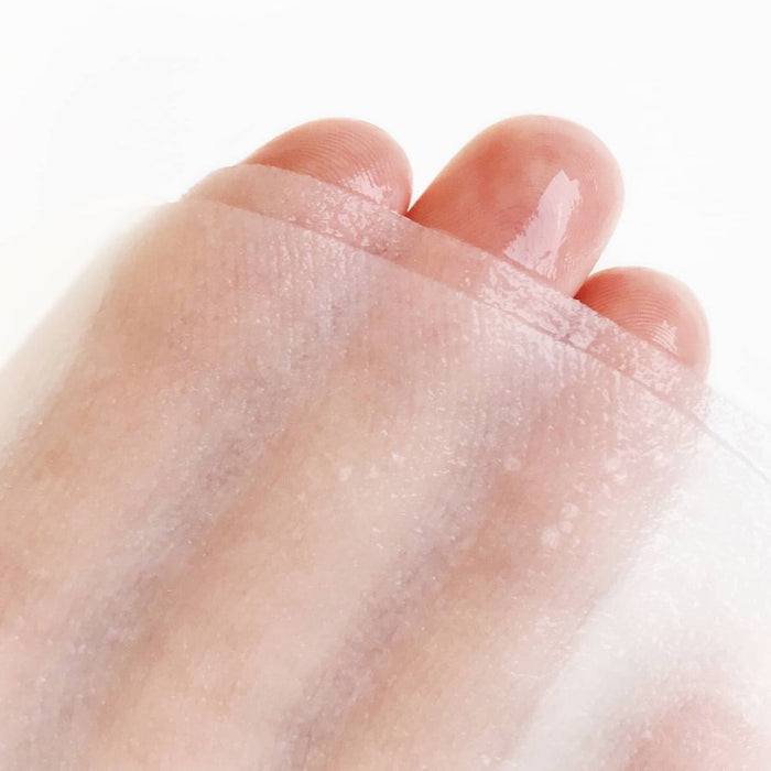 Close-up of a hand draped in a translucent, serum-soaked sheet mask, highlighting its ultra-thin, breathable fabric designed for maximum absorption and deep hydration.