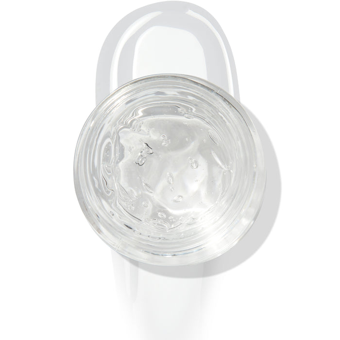 In The Clear Face & Eye Gloss in an open round jar gleams with a glossy swipe beneath it on a white background, showcasing the ColourPop Face & Eye Gloss for dewy, glass-skin shine on lids and cheeks.