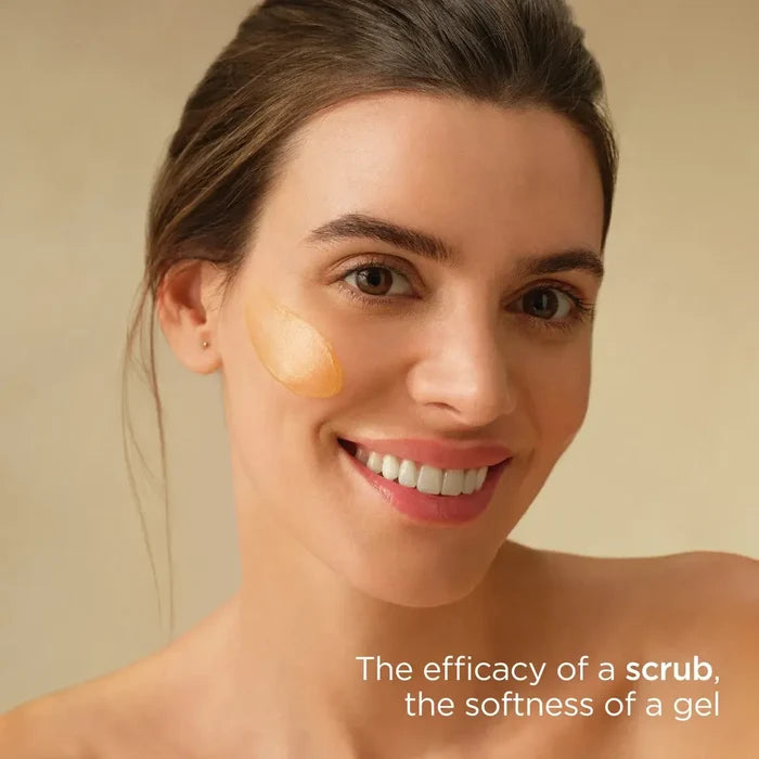 Woman applying ISDIN Essential Scrub on cheek, with text: The efficacy of a scrub, the softness of a gel