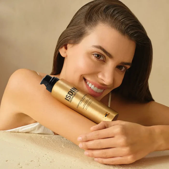 ISDIN Isdinceutics Essential Purifier foaming cleanser bottle held by smiling woman