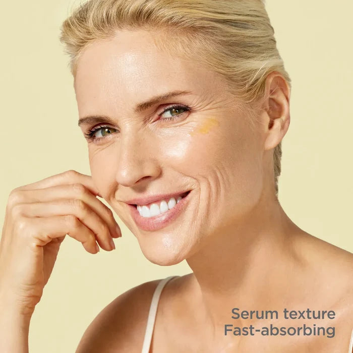 Woman applying Flavo-C serum with fast-absorbing texture on brightened skin