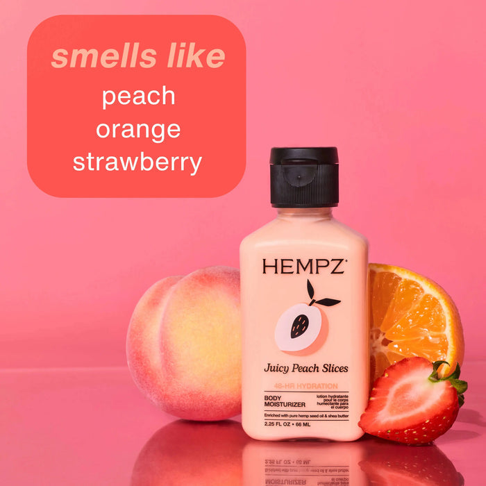 Hempz mini body moisturizer bottle with peach, orange, and strawberry on a pink background