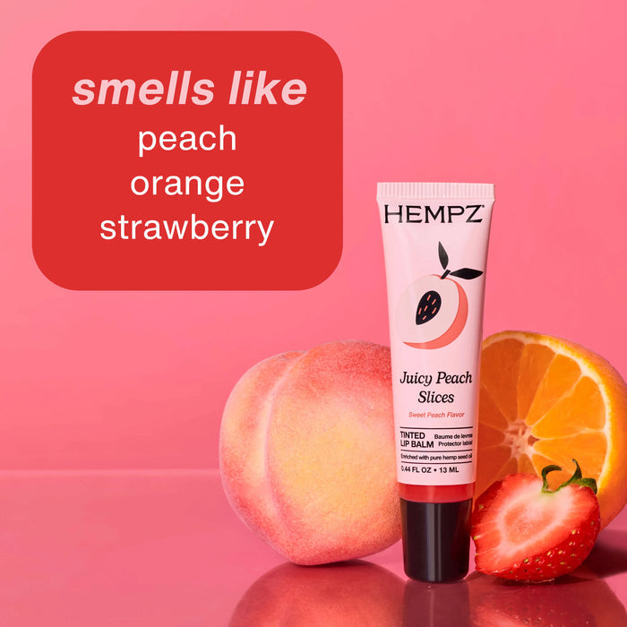 Hempz lip balm with peach, orange, and strawberry on a pink background