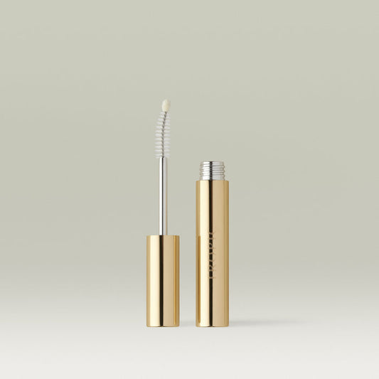 Open Lashful Eyelash Growth Serum featuring its gold tube and innovative dual-ended applicator with spoolie brush and precision tip, displayed on a reflective surface.