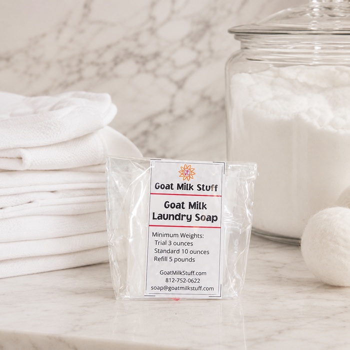 Goat Milk Laundry Soap package with towels and a jar in the background