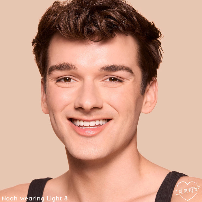 ColourPop Pretty Fresh Tinted Foundation Balm in Light 8 smoothing a smiling model’s complexion, showing light coverage with a natural dewy finish; close-up portrait on a beige background with a small ColourPop heart logo in the corner.