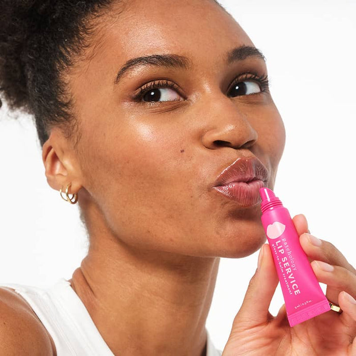 Woman applies Lip Service gloss to balm lip smoothing gloss to hydrate dry cracked lips