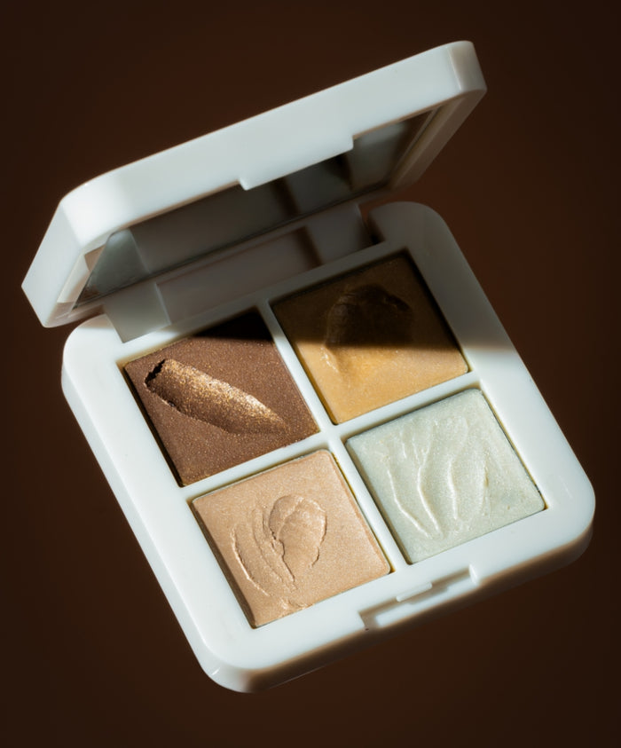 Living Luminizer Glow Quad Mini with four shimmering highlighter shades in a white compact case, showcasing natural and radiant makeup looks using clean beauty ingredients.