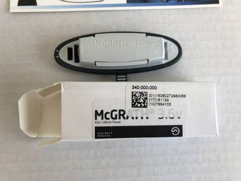A 3.6v lithium power battery rests atop its white packaging; the box displays McGRATH branding and product codes: 340-000-000, (01)15080272980088, (17)181124, and (10)7884103.