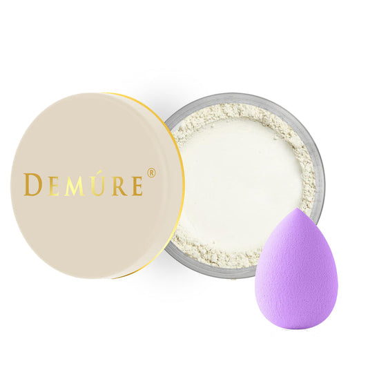 Open container of Demure Mint Concealer eye color with a gold lid. and a beauty blender applicator
