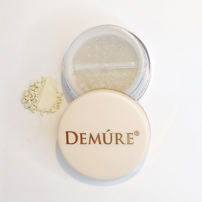 A jar of Demure Mint concealer with the lid off and a swatch of the color beside it.