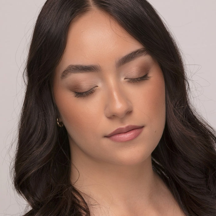 Close-up of a woman with closed eyes wearing Demure Tan Finishing Powder