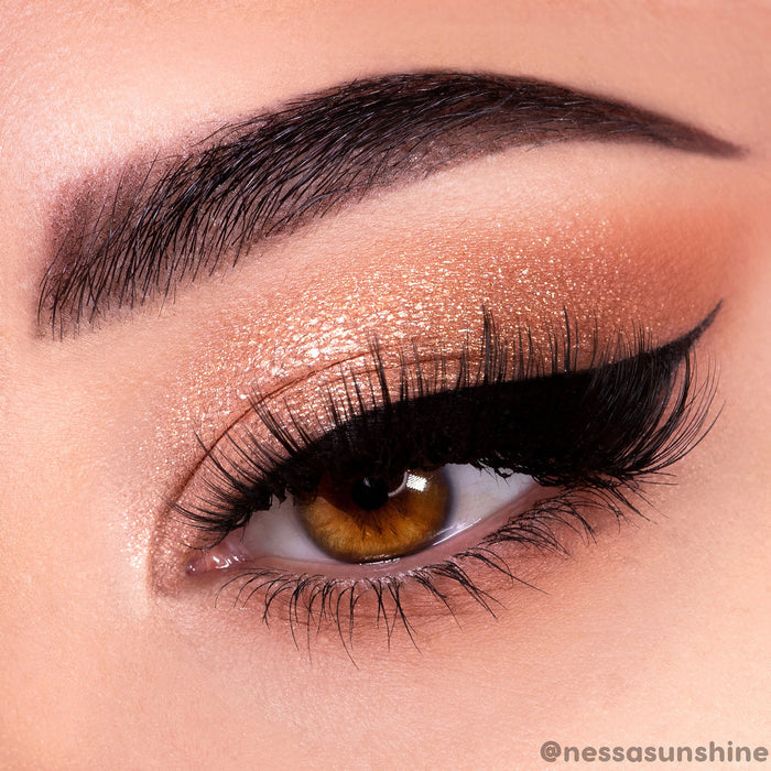 Shimmery warm nude eye showcasing the Nude Mood ColourPop Shadow Palette - copper and champagne shades blended on the lid with matte tan crease, dramatic black winged liner, and full lashes, close-up beauty product shot.