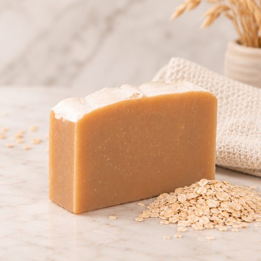 Bar of goat milk soap with oatmeal in the background on a marble top