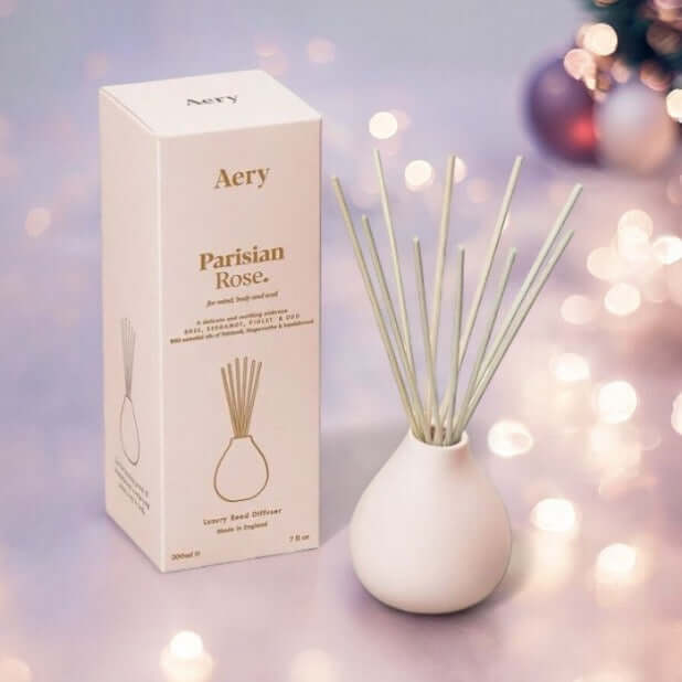 Parisian Rose reed diffuser in an elegant white container with a minimalist design and packaging on a softly lit background.