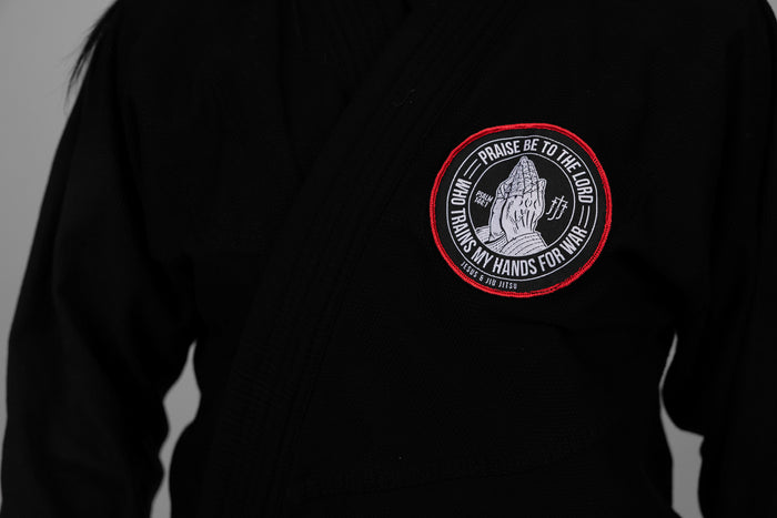 4in Patch with praying hands design and "PRAISE BE TO THE LORD WHO TRAINS MY HANDS FOR WAR" text on a black gi