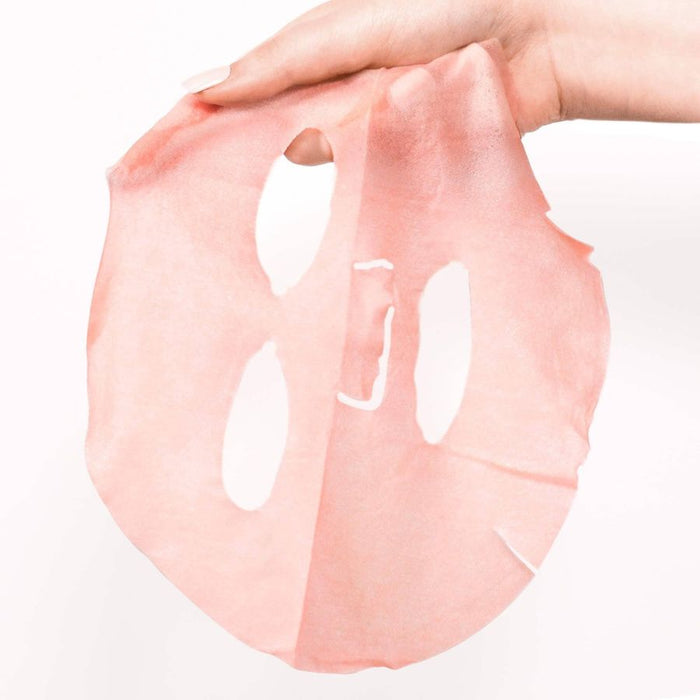 Hand holding a shimmering pink sheet mask against a white background, highlighting its delicate texture and brightening formula for a revitalizing skincare experience.