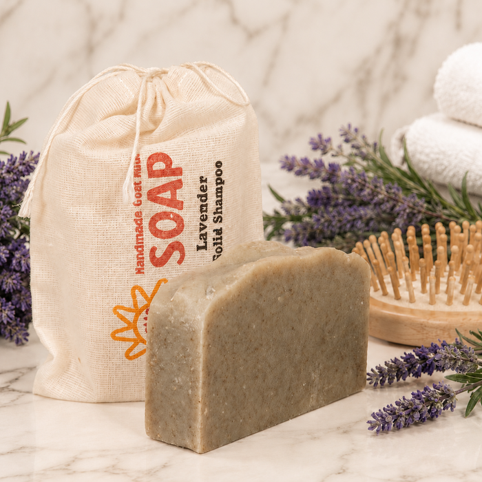 Bar of soap with a drawstring bag labeled 'Soap' and lavender flowers on a marble surface.
