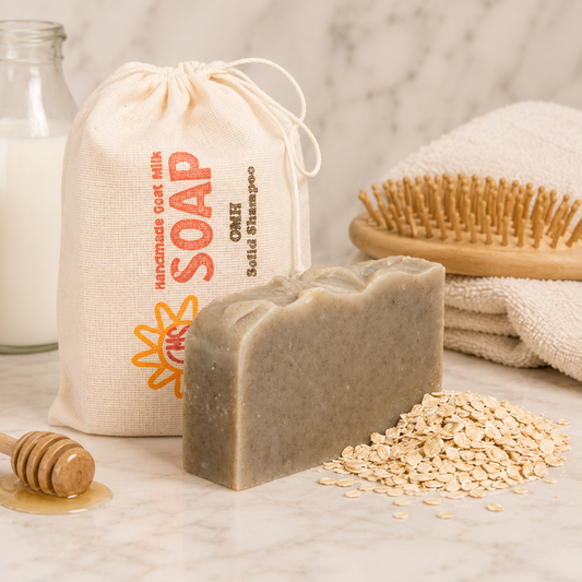 Bar of soap with a drawstring bag labeled 'Soap' and a wooden brush on a neutral background.