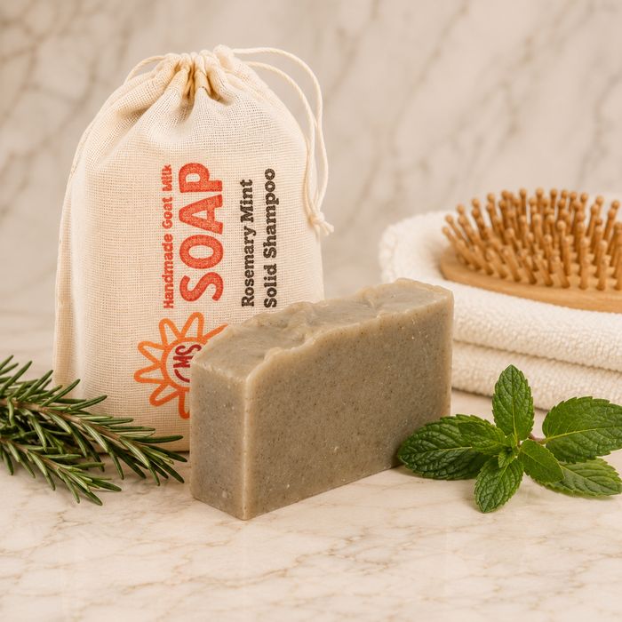 Bar of soap with a drawstring bag labeled 'Handmade Goat Milk Soap' on a marble surface.