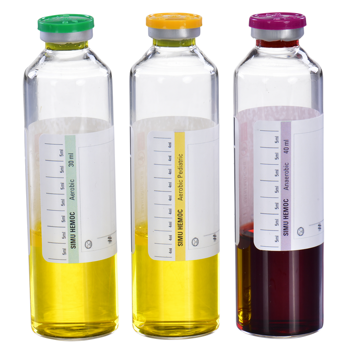 Three glass vials containing yellow and red liquids sit side-by-side. Labels indicate "SIMU HEMOC," aerobic and anaerobic conditions, and volume measurements.